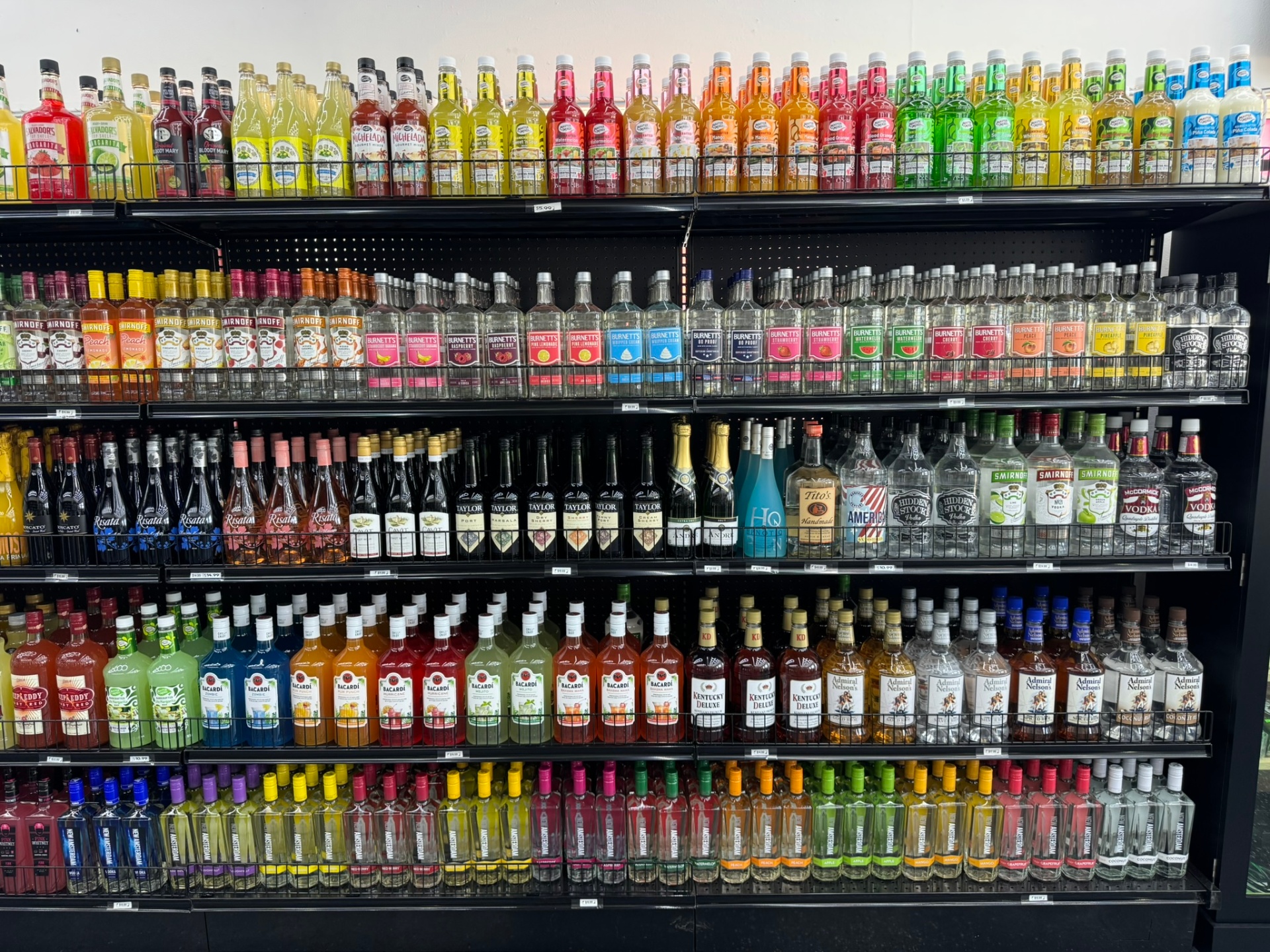 Floor-to-ceiling shelves of mixers, vodka and flavored spirits